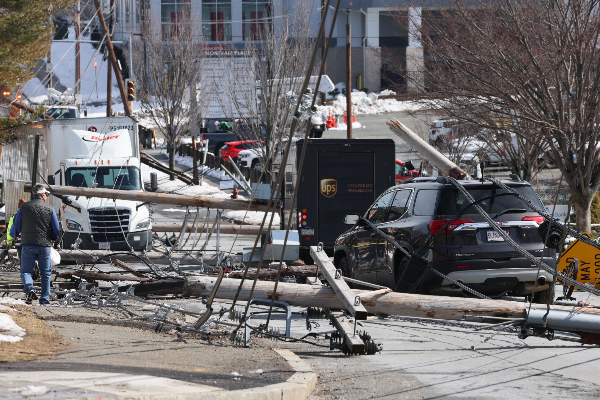 Seven utility poles carrying power liens fell along a street in Stoneham, Massachusetts, on Wednesday, March 1, 2023.