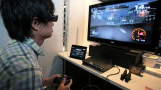 A visitor plays 'Ridge Racer 7' on a 3D-supported PlayStation 3