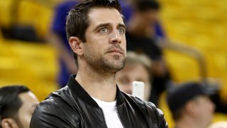 In this June 17, 2017, file photo, quarterback Aaron Rodgers of the Green Bay Packers watches warm-ups before the Golden State Warriors take on the Cleveland Cavaliers in Game 5 of the 2017 NBA Finals at ORACLE Arena in Oakland, California.