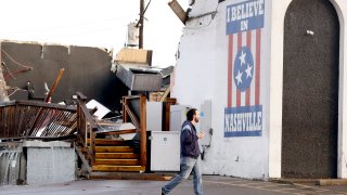 A man walks by The Basement East, a live music venue destroyed by storms Tuesday, March 3, 2020, in Nashville, Tenn.