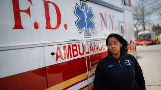 911 dispatcher stands next to ambulance