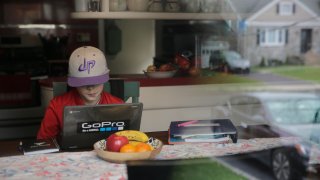 Colin Powers, 9, streams a math lesson broadcast by public television on a laptop at his home in Union, N.J.