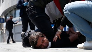 In this May 1, 2020, file photo, Turkish police officers arrest a demonstrator wearing a face mask for protection against the coronavirus, during May Day protests near Taksim Square, in Istanbul. The death of George Floyd has renewed scrutiny of immobilization techniques long used in policing around the world.