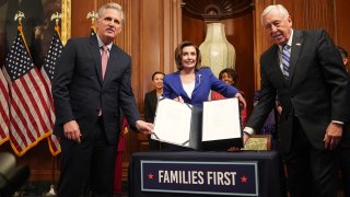 In this file photo, House Speaker Nancy Pelosi and Reps. Kevin McCarthy (left) and Steny Hoyer pose after signing a $2 trillion coronavirus relief bill, on March 27, 2020, at the Capitol in Washington, D.C.