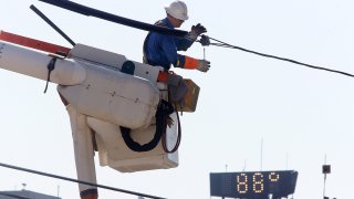a Central Maine Power lineworker adds protective insulation to power lines