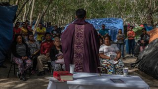 A priest holds a mass for asylum seekers at a makeshift migrant camp in Matamoros, Tamaulipas state, Mexico