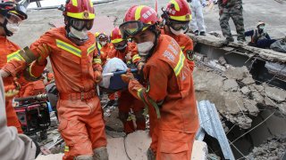A man is rescued from the rubble of a collapsed hotel