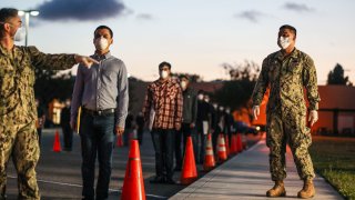 U.S. Marine recruits stand in formation as they wait in line for health screenings at the Marine Corps Recruit Depot (MCRD) on April 13, 2020