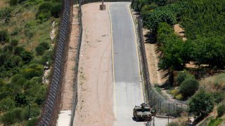 A picture taken on June 14, 2020 from the village of Majdal Shams in the Israeli-annexed Golan Heights shows an Israeli military vehicle patrolling the border fence with Syria.