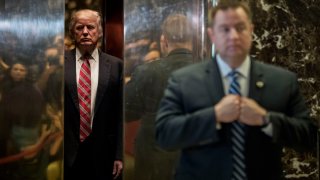 In this Jan. 16, 2017, file photo, president-elect Donald Trump heads back into the elevator after shaking hands with Martin Luther King III after their meeting at Trump Tower in New York City.