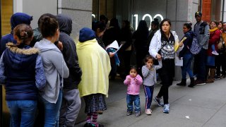 In this Jan. 31, 2019, file photo, hundreds of people overflow onto the sidewalk in a line snaking around the block outside a U.S. immigration office with numerous courtrooms in San Francisco.