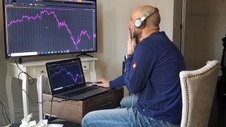 In this April 6, 2020, file photo provided by Meric Greenbaum, a Designated Market Maker with IMC works in his home office in Shelter Island, New York.