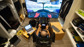 IndyCar driver Tony Kanaan, of Brazil, practices on his racing simulator in his home