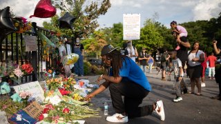 In this June 14, 2020, file photo, a man kneels at the memorial for Rayshard Brooks in Atlanta, Georgia.