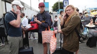 Tourists from the United States wait outside the closed Jorge Chavez International Airport in Callao, Peru