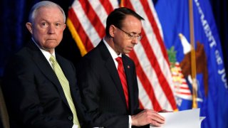 In this June 10, 2017, file photo, Attorney General Jeff Sessions, left, and Deputy Attorney General Rod Rosenstein take their seats at the Justice Department's National Summit on Crime Reduction and Public Safety, in Bethesda, Md.