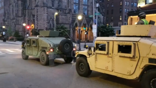 Massachusetts National Guard vehicles drive through Boston.