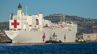 In this March 27, 2020, file photo, tugboats guide the USNS Mercy hospital ship to moor at the Port of Los Angeles in Los Angeles, California, U.S.
