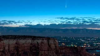 Comet Neowise soars in the horizon of the early morning sky in this view from the near the grand view lookout at the Colorado National Monument west of Grand Junction, Colo., Thursday, July 9, 2020. The newly discovered comet is streaking past Earth, providing a celestial nighttime show after buzzing the sun and expanding its tail.