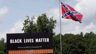 A Black Lives Matter billboard is seen next to a Confederate flag in Pittsboro, N.C., Thursday, July 16, 2020. A group in North Carolina erected the billboard to counter the flag that stands along the road.