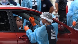 In this July 22, 2020, file photo, a woman in a car is tested for COVID-19 at a drive-thru testing site at Camping World Stadium in Orlando, Florida.