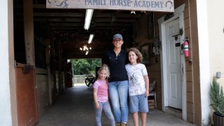 Timea Hunter poses for a photograph with her children Lena, left, and Liam, right, at the Family Horse Academy, where she is hoping to organize education for a group of children during the coronavirus pandemic, Friday, July 31, 2020, in Southwest Ranches, Fla. Confronting the likelihood of more distance learning, families across the country are turning to private tutors and "learning pods" to ensure their children receive some in-person instruction. The arrangements raise thorny questions about student safety, quality assurance, and inequality.