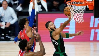 Jayson Tatum #0 of the Boston Celtics drives to the basket against Joel Embiid #21 and Matisse Thybulle #22 of the Philadelphia 76ers during the first half at The Field House at ESPN Wide World Of Sports Complex on August 17, 2020 in Lake Buena Vista, Florida.
