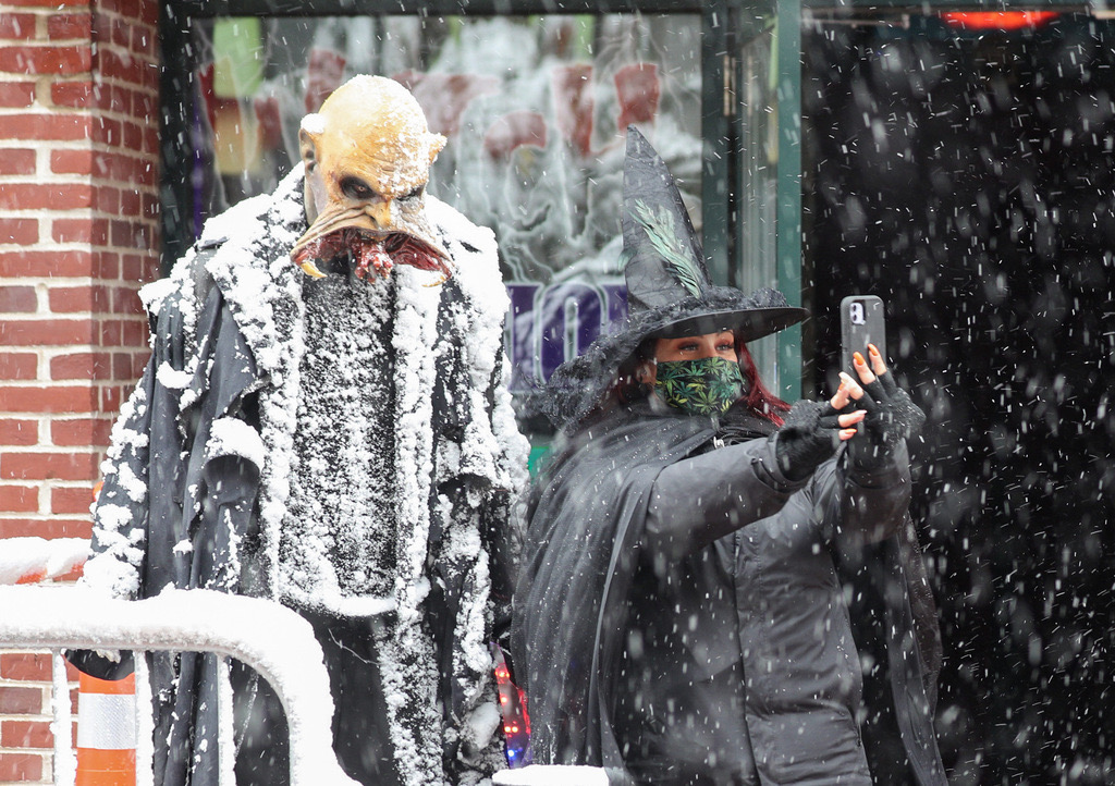 A woman takes a selfie photo with a character in Salem, Mass.