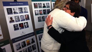 Survivor Bridget Lyons hugs a man after a press conference in New York