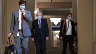 Senate Majority Leader Mitch McConnell, a Republican from Kentucky, center, wears a protective mask as he departs the U.S. Capitol