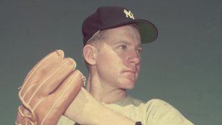 circa 1955: New York Yankees pitcher Whitey Ford wearing a baseball glove while preparing to throw a baseball.