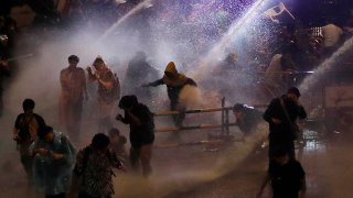 Police use water canons to try and disperse demonstrators from their protest venue in Bangkok, Thailand, Oct. 16, 2020.