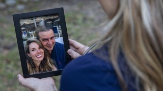 Paige King holds a photo of herself with her partner, Dr. Carlos Araujo-Preza.