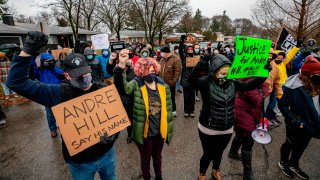 Protesters raise their fists and observe a moment of silence during a demonstration against the police killing of Andre Hill in the neighborhood where Hill was shot, in Columbus, Ohio, on December 24, 2020.