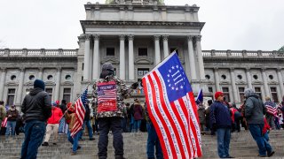 A protester holds a Betsy Ross Three Percent flag during a demonstration