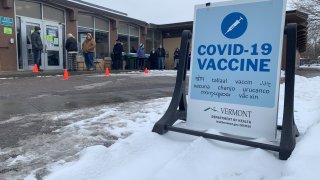 A line of people wait outside in Vermont for a coronavirus vaccine.