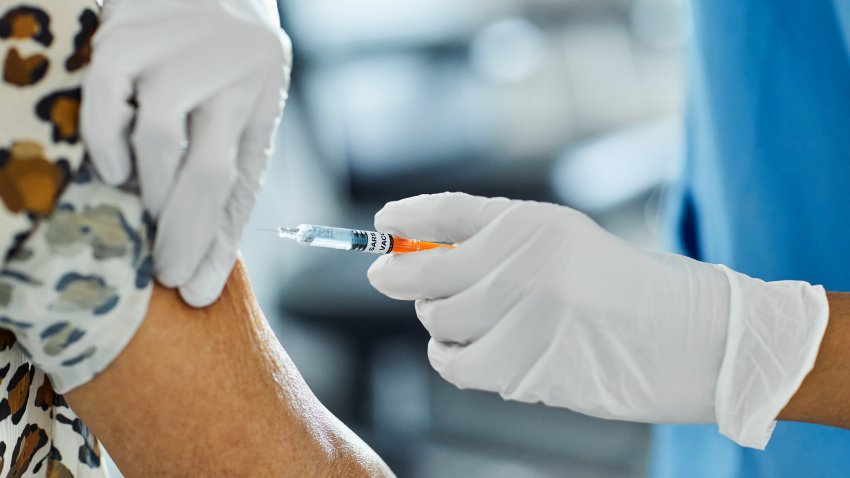 Cropped image of nurse injecting Covid-19 Vaccine to a patient. Female healthcare worker is working at hospital. She is holding syringe.