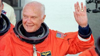 KENNEDY SPACE CENTER, UNITED STATES: US astronaut and senator John Glenn waves as he leaves the Operations and Check out building at the Kennedy Space Center, FL, 29 October in route to board the US space shuttle Discovery. The seven person crew will perform several scientific experiments during their nine day mission, including studies on the effects of weightlessness on 77-year-old Glenn. Glenn who is 77 years old will be the oldest man to fly into space. October 29, 1998