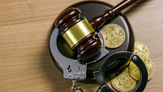 A gavel, handcuffs and cryptocurrency