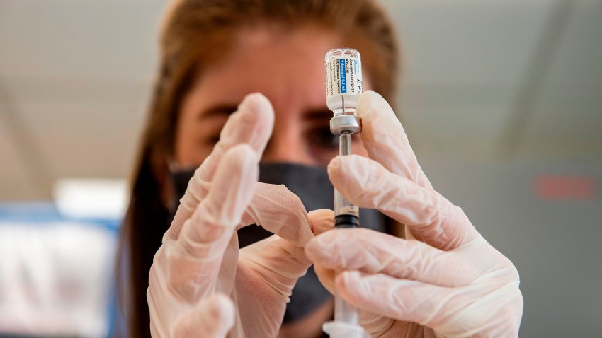 Healthcare worker holds up a vial of the covid vaccine