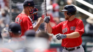 Christian Arroyo #39 of the Boston Red Sox high fives teammates after hitting a solo home run in a spring training game