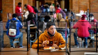 freshman Hugo Bautista eats lunch separated from classmates by plastic dividers at Wyandotte County High School in Kansas City