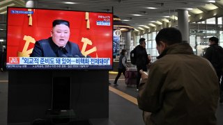 People watch a television screen at Suseo railway station in Seoul on March 26, 2021, showing file footage of North Korea's leader Kim Jong Un as a news programme reports about the North's latest tactical guided projectile test.