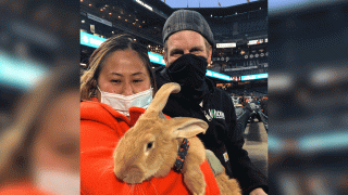 Kei Kato, left, and her fiance, Josh Row, hold a therapy bunny named Alex during a baseball game between the San Francisco Giants and the Miami Marlins in San Francisco, Thursday, April 22, 2021.