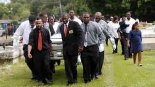 Pall bearers carry the casket of Alton Sterling to his gravesite at the Mount Pilgrim Benevolent Society Cemetery July 15, 2016 in Baton Rouge, Louisiana. Sterling was shot July 5 outside a Baton Rouge convenience store in an encounter with police that was caught on video.