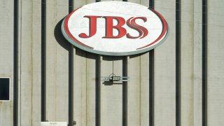 In this Oct. 12, 2020, file photo, a worker heads into the JBS meatpacking plant in Greeley, Colorado.