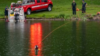 Worcester Fire Department divers search Green Hill Pond after reports of a drowning Friday, June 4, 2021. in Worchester, Mass. A Massachusetts police officer drowned Friday while attempting to rescue a teenage boy, who also drowned at the pond.(Rick Cinclair/Worcester Telegram & Gazette via AP)