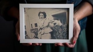 Stacy Cordova, whose aunt was a victim of California's forced sterilization program that began in 1909, holds a framed photo of her aunt Mary Franco, Monday, July 5, 2021, in Azusa, Calif. Franco was sterilized when she was 13 in 1934. Franco has since died, but Cordova has been advocating for reparations on her behalf.