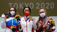 Silver medalist Anastasiia Galashina, left, of the Russian Olympic Committee, gold medalist Yang Qian, of China, center, and bronze medalist Nina Christen, of Switzerland stand after the women's 10-meter air rifle at the Asaka Shooting Range in the 2020 Summer Olympics, Saturday, July 24, 2021, in Tokyo, Japan.
