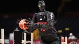 SAITAMA, JAPAN - JULY 25: A robot plays basketball during halftime of the Men's Preliminary Round Group B game between the United States and France on day two of the Tokyo 2020 Olympic Games at Saitama Super Arena on July 25, 2021 in Saitama, Japan.